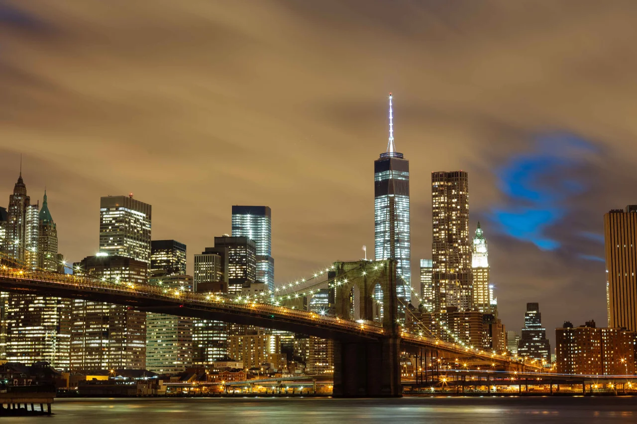 The Brooklyn Bridge crossing the East River with the Manhattan skyline behind it.